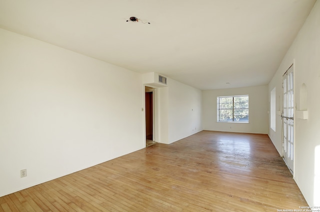 spare room with light hardwood / wood-style floors and french doors