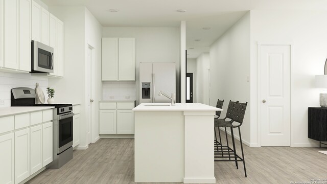 kitchen featuring a center island with sink, white cabinetry, and appliances with stainless steel finishes