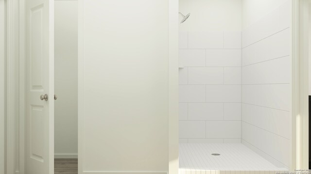 bathroom featuring tiled shower and wood-type flooring