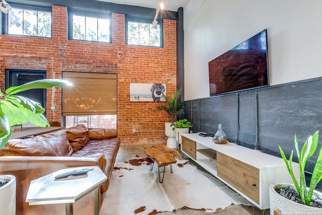 living room featuring concrete floors and brick wall