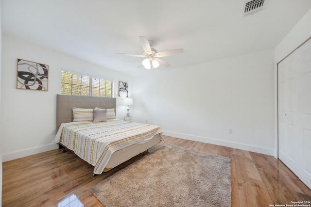 bedroom with light hardwood / wood-style flooring, a closet, and ceiling fan