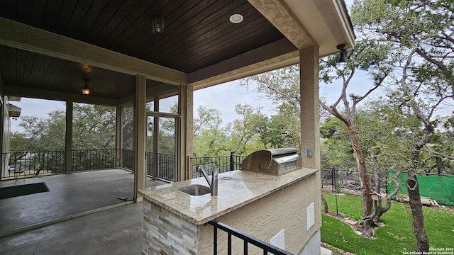 view of patio with grilling area, an outdoor kitchen, a sink, and fence