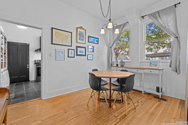 dining room with hardwood / wood-style flooring and a notable chandelier