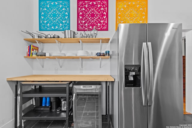 kitchen featuring stainless steel fridge with ice dispenser and beverage cooler