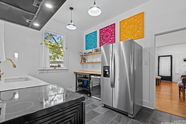 kitchen featuring stainless steel refrigerator with ice dispenser, sink, pendant lighting, black range, and wine cooler