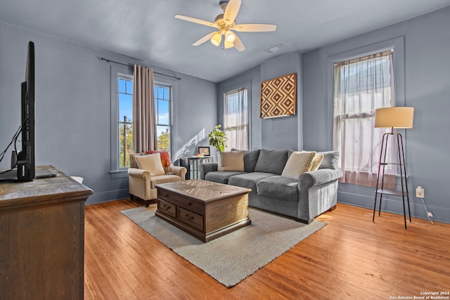 living room with ceiling fan, a healthy amount of sunlight, and light wood-type flooring