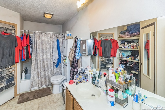 full bathroom featuring shower / bath combo with shower curtain, vanity, a textured ceiling, and toilet