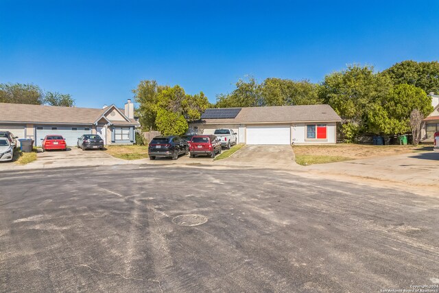 ranch-style home with solar panels and a garage