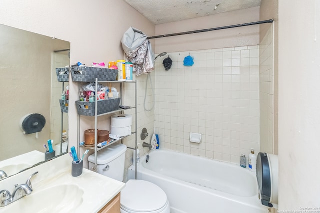 full bathroom featuring vanity, tiled shower / bath combo, a textured ceiling, and toilet