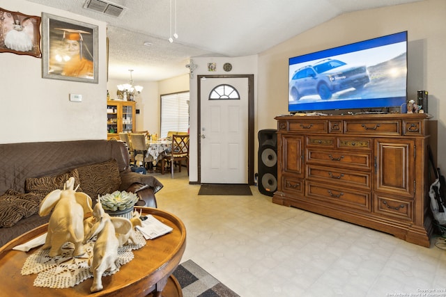 living room featuring vaulted ceiling, a textured ceiling, and a notable chandelier