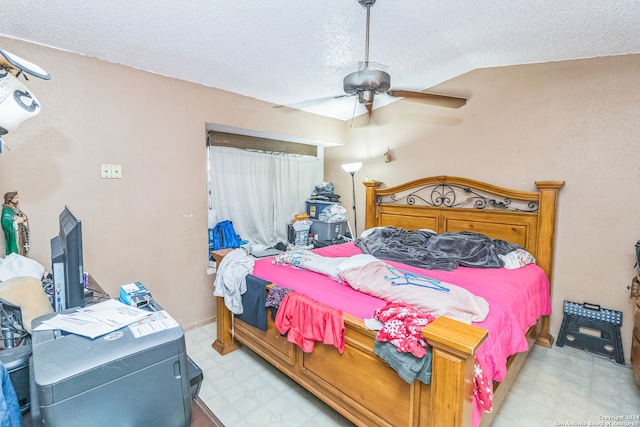 bedroom featuring ceiling fan, a textured ceiling, and vaulted ceiling