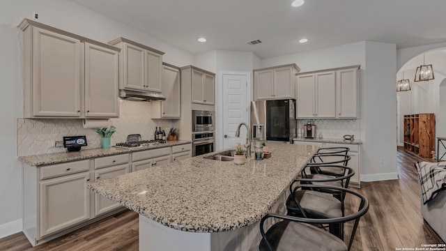 222 Sigel Ave, New Braunfels, TX 78132 - kitchen featuring stainless steel appliances, a sink, a kitchen bar, arched walkways, and recessed lighting
