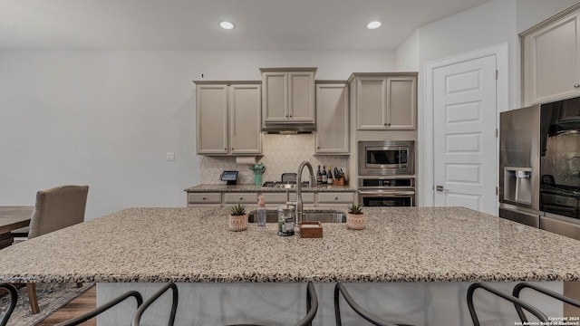 222 Sigel Ave, New Braunfels, TX 78132 - kitchen with stainless steel appliances, a kitchen breakfast bar, light stone countertops, tasteful backsplash, and recessed lighting