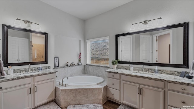 222 Sigel Ave, New Braunfels, TX 78132 - bathroom with a bath, two vanities, and wood finished floors