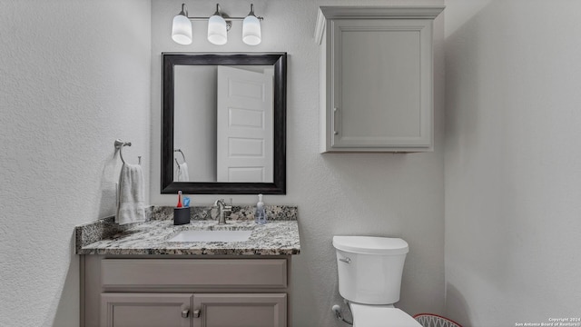 222 Sigel Ave, New Braunfels, TX 78132 - bathroom featuring vanity, toilet, and a textured wall