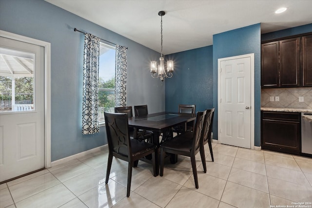 tiled dining room featuring a chandelier