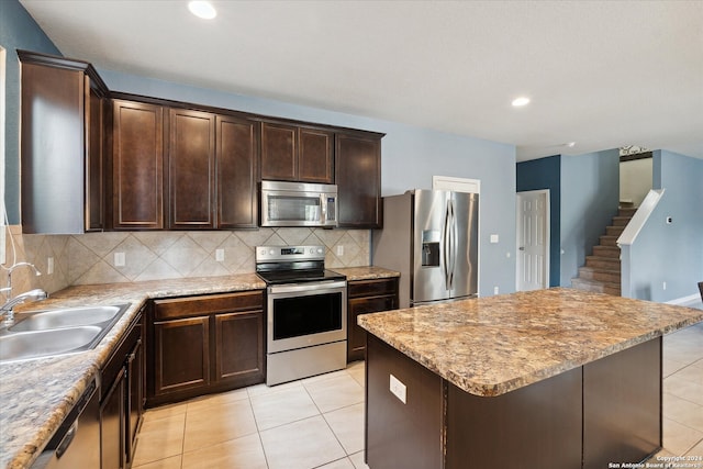 kitchen featuring light tile patterned flooring, appliances with stainless steel finishes, backsplash, and sink