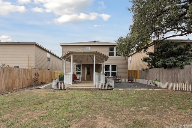 rear view of property featuring a lawn, a patio area, and central AC unit