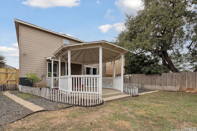 rear view of house with a yard and cooling unit