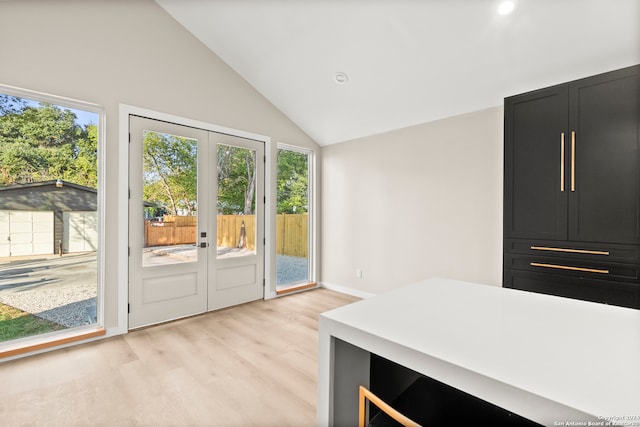 doorway to outside featuring french doors, light hardwood / wood-style flooring, and lofted ceiling