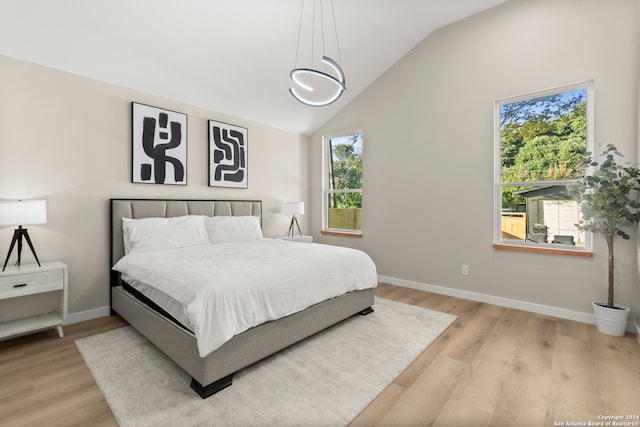 bedroom with light hardwood / wood-style floors and lofted ceiling