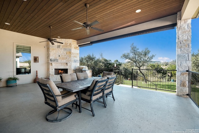 view of patio with grilling area, ceiling fan, and an outdoor stone fireplace