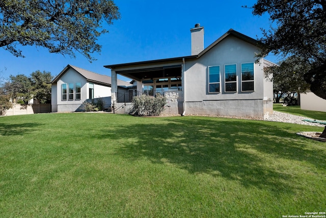 rear view of property featuring a yard