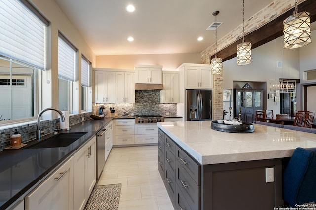 kitchen featuring gray cabinetry, sink, decorative light fixtures, white cabinets, and appliances with stainless steel finishes