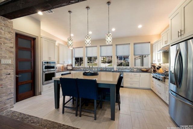 kitchen featuring white cabinets, extractor fan, backsplash, and appliances with stainless steel finishes