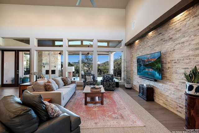 living room featuring a towering ceiling, dark wood-type flooring, a wealth of natural light, and french doors