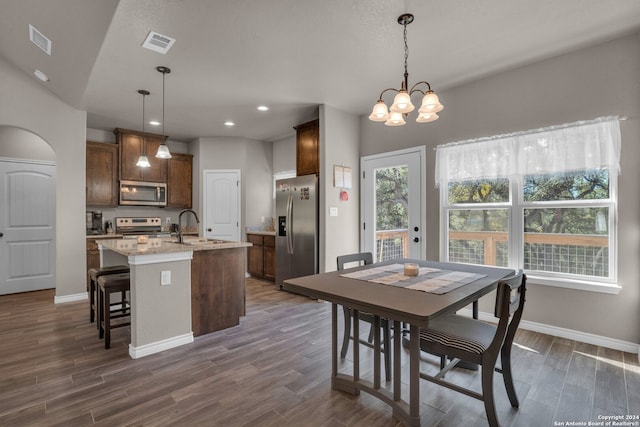 dining room with lofted ceiling, an inviting chandelier, dark wood-type flooring, and sink