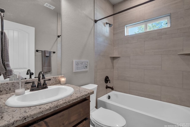 full bathroom with vanity, toilet, and tiled shower / bath