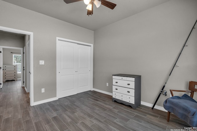 living area featuring ceiling fan and dark wood-type flooring