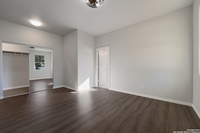 unfurnished bedroom with dark hardwood / wood-style floors and a closet