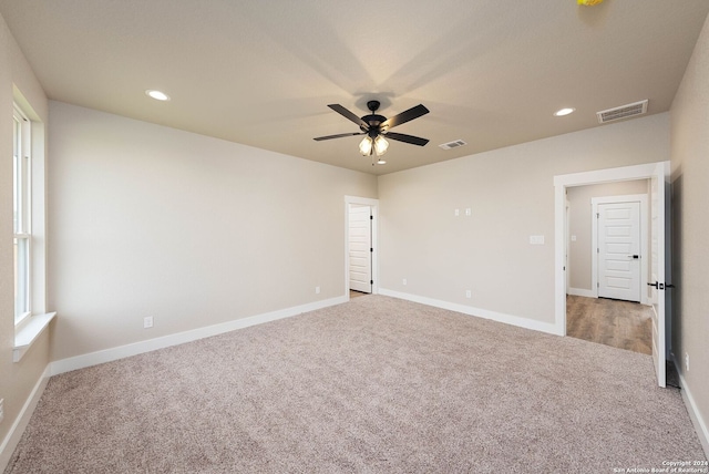 carpeted spare room featuring ceiling fan