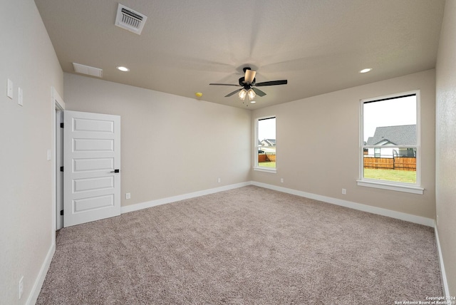 carpeted spare room featuring ceiling fan