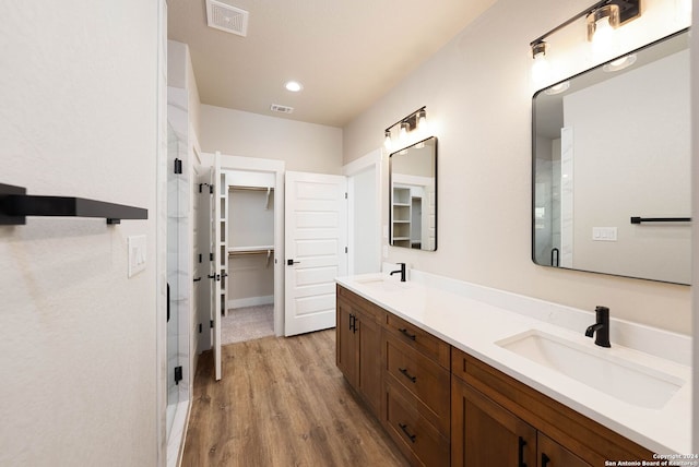 bathroom with a shower with door, vanity, and hardwood / wood-style flooring