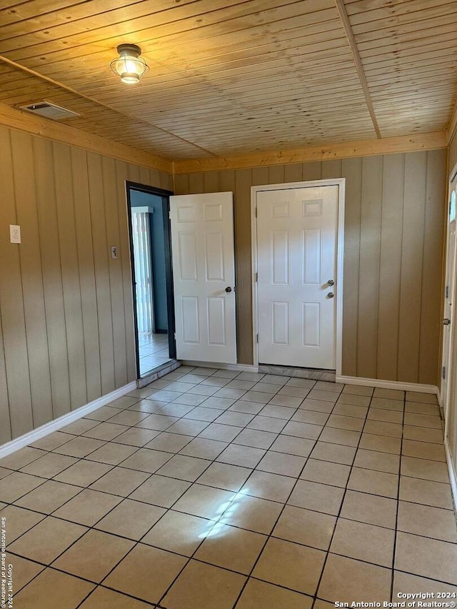 unfurnished bedroom featuring wooden ceiling and light tile patterned floors