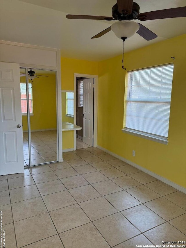 spare room with ceiling fan and light tile patterned floors