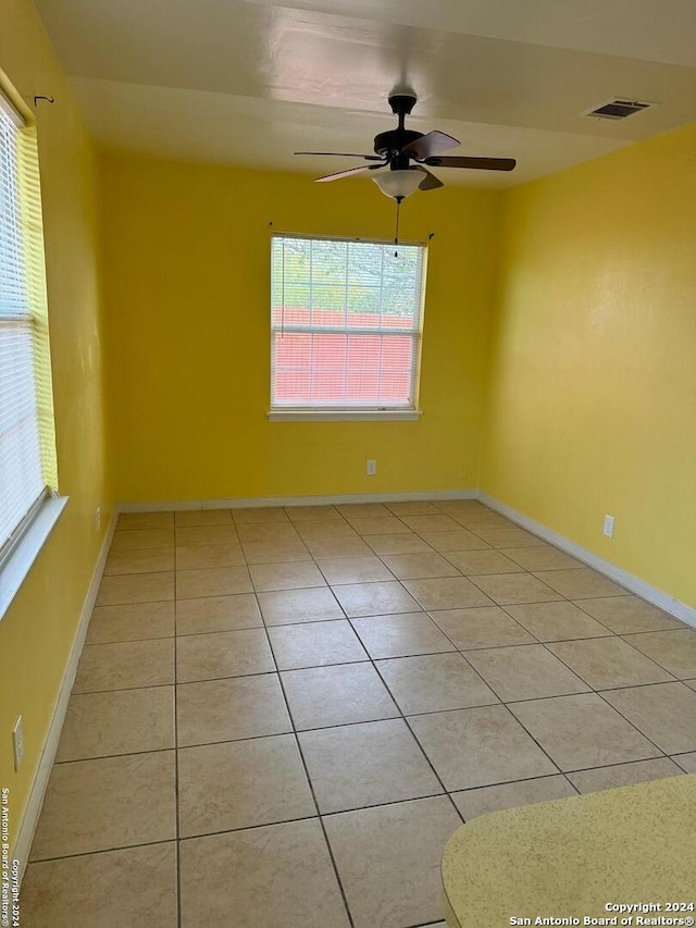 tiled spare room featuring ceiling fan