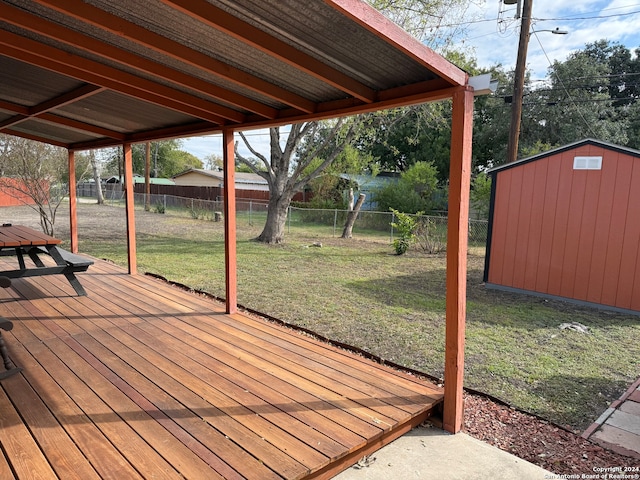 wooden deck with a yard and a storage unit