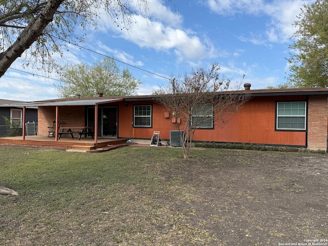 rear view of property with a wooden deck, cooling unit, and a lawn