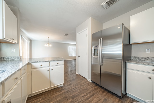 kitchen with white cabinets, hanging light fixtures, dark hardwood / wood-style floors, stainless steel fridge, and kitchen peninsula