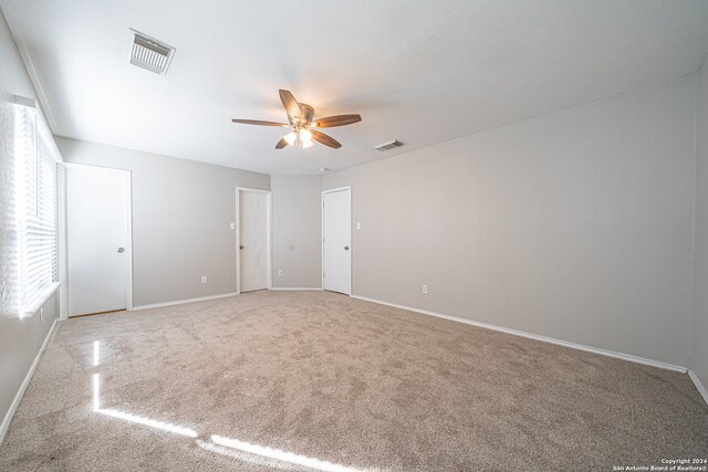 unfurnished room featuring ceiling fan and carpet floors