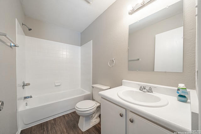 full bathroom featuring vanity, a textured ceiling, washtub / shower combination, hardwood / wood-style floors, and toilet