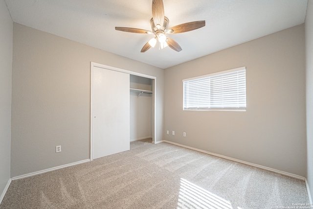 unfurnished bedroom featuring light carpet, a closet, and ceiling fan