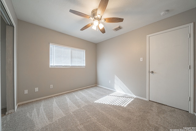 unfurnished bedroom with ceiling fan and light colored carpet