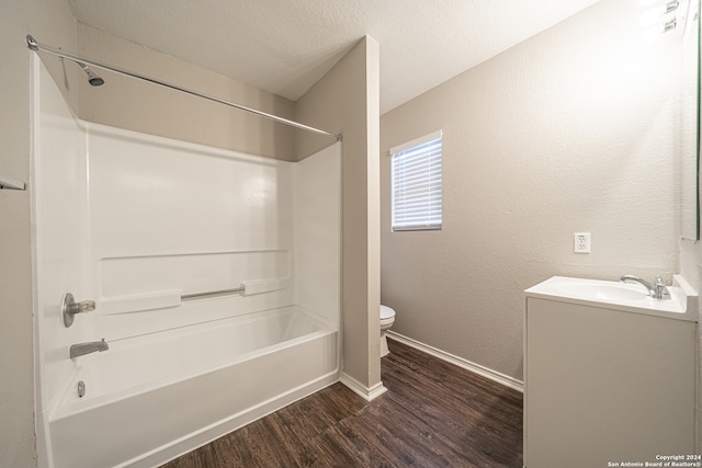 full bathroom featuring vanity, wood-type flooring, toilet, a textured ceiling, and shower / bath combination