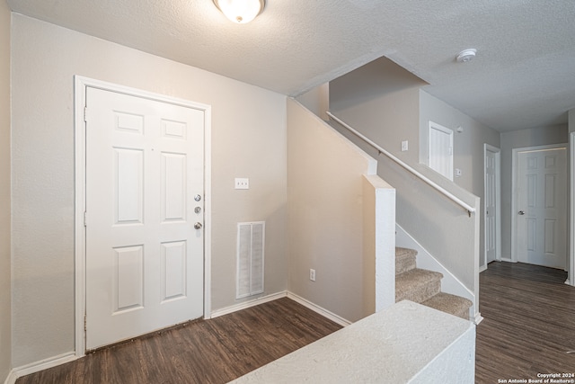 entryway featuring a textured ceiling and dark hardwood / wood-style floors