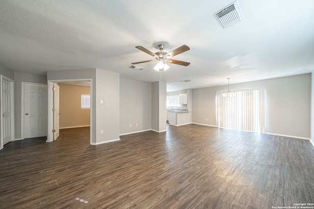 spare room with a textured ceiling, dark hardwood / wood-style flooring, and ceiling fan with notable chandelier